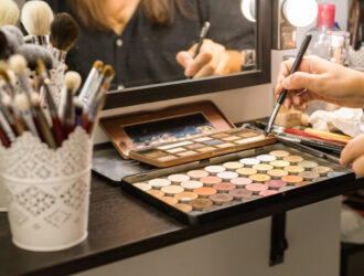 Makeup brushes and make-up in the shadow of the hands, in the beauty salon